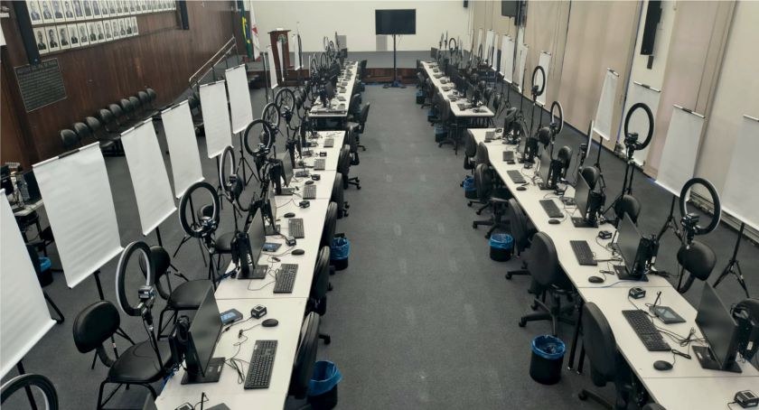 Foto mostra guichês de atendimento ao eleitor no auditório do TRE-MG. O ambiente conta com dezen...