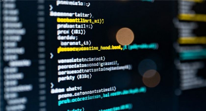 Imagem com fundo preto e códigos de programação escritos em branco, amarelo e azul turquesa