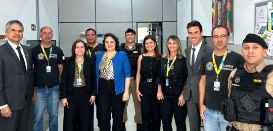 Foto mostra três mulheres e três homens de pé, conversando.