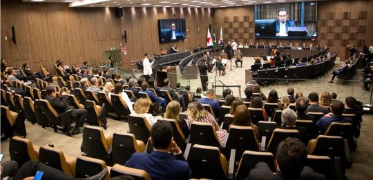 1º Encontro de Cooperação Judiciária MG Foto do Tribunal Pleno do TJMG. Em primeiro plano, várias pessoas sentadas na plateia. Ao fundo,...