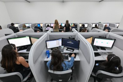 Coordenadora de acessibilidade auxilia um eleitor com deficiência visual