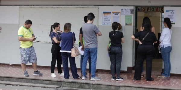Foto mostra eleitores em fila na porta de uma seção eleitoral