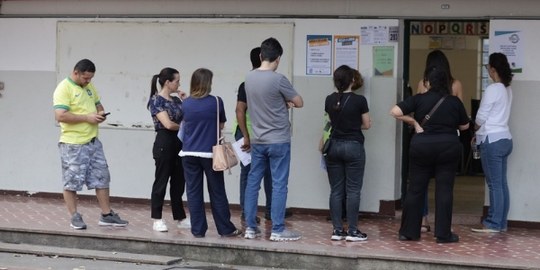 Foto mostra eleitores em fila na porta de uma seção eleitoral