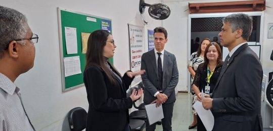 Foto mostra três mulheres e três homens de pé, conversando.