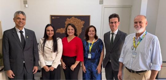 Foto mostra três mulheres e três homens de pé, olhando para a câmera.