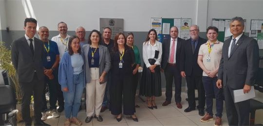 Foto mostra três mulheres e três homens de pé, conversando.