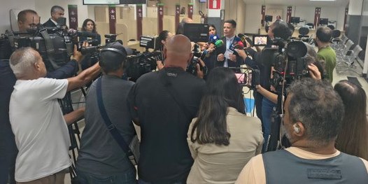 Eleitora é filmada por jornalista enquanto treina o voto na urna eletrônica com simulador.