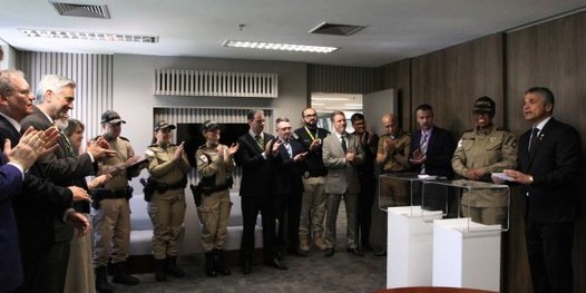 Foto do desembargador Carlos Henrique Perpétuo Braga durante discurso, observado por uma mulher ...