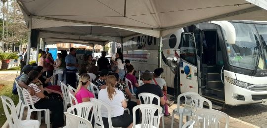 Foto mostra uma eleitora idosa e sua acompanhante durante atendimento no ônibus TRE Aqui.