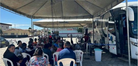 Foto mostra uma eleitora idosa e sua acompanhante durante atendimento no ônibus TRE Aqui.