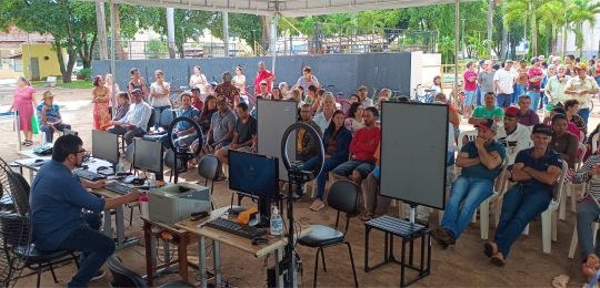 Foto mostra uma eleitora idosa e sua acompanhante durante atendimento no ônibus TRE Aqui.
