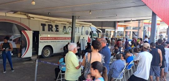 Foto mostra uma eleitora idosa e sua acompanhante durante atendimento no ônibus TRE Aqui.