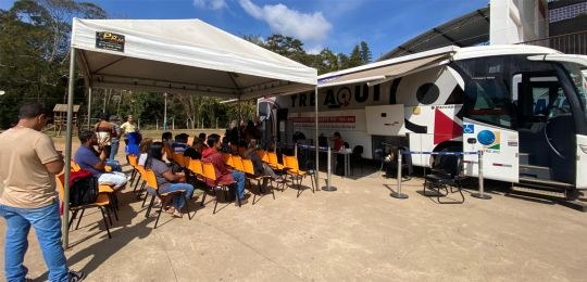 Foto mostra uma eleitora idosa e sua acompanhante durante atendimento no ônibus TRE Aqui.
