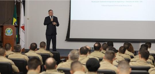 Desembargador Paulo Tamburini durante palestra. Em primeiro plano, policiais militares na platei...