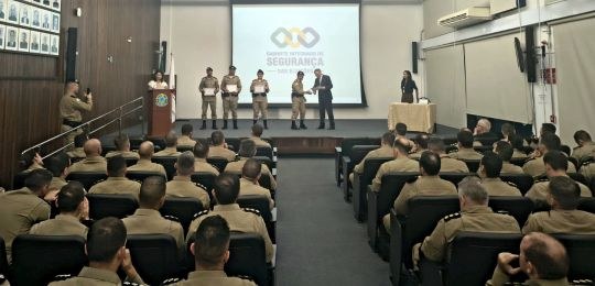 Wellerson Amarante, secretário de TI do TRE-MG, durante palestra. Junto dele há um telão com inf...