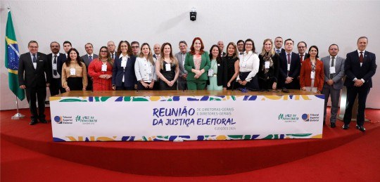 Diretoras e diretores-gerais da Justiça Eleitoral posam para a foto em um auditório.