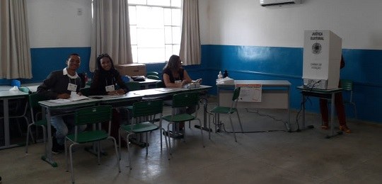 Foto mostra eleitores na entrada de uma escola estadual.