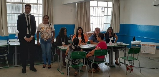 Foto mostra eleitores na entrada de uma escola estadual.