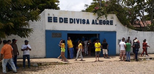 Foto mostra eleitores na entrada de uma escola estadual.