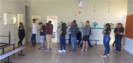 Foto mostra homens e mulheres na fila em frente a uma seção eleitoral