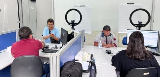 Foto mostra dois homens sendo atendidos por uma servidora e um servidor do TRE.