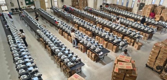 Manutenção das urnas eletrônicas - TRE-MG Foto tirada de cima mostra bancadas com dezenas de urnas eletrônicas