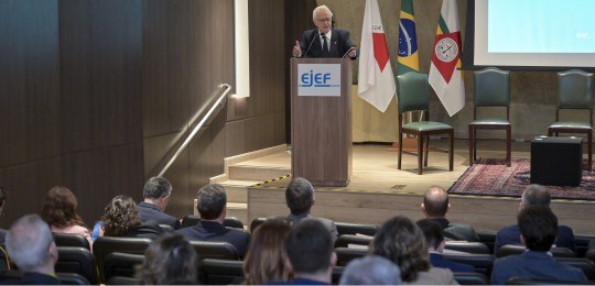 Desembargador Júlio César Lorens durante discurso. Ele está de pé, no canto esquerdo da foto. À ...