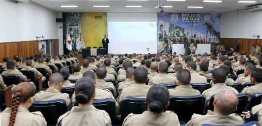 palestra vice-presidente TRE-MG na PMMG Foto mostra, em primeiro plano, dezenas de policiais militares sentados em um auditório. Ao fund...