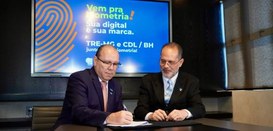 Desembargador Júlio César Lorens observa Marcelo Souza e Silva assinando um documento. Os dois e...