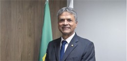 Des. Carlos Henrique Braga posa à frente das bandeiras de Minas e do Brasil