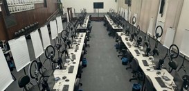 Foto mostra diversos guichês de atendimento ao eleitor montados dentro de um auditório. O espaço...