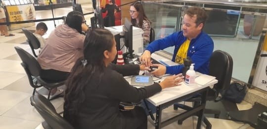 Foto mostra servidor do TRE colhendo a biometria de uma eleitora.