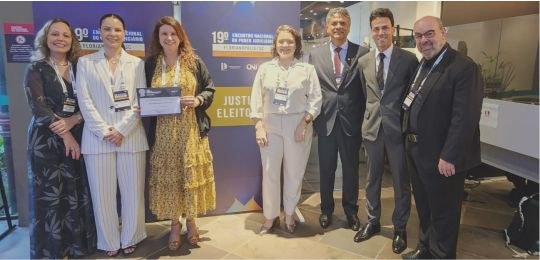 Prêmio CNJ de Qualidade 2025 Foto mostra representantes do TRE-MG no evento do CNJ. São quatro mulheres e três homens.