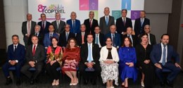 Presidentes dos TREs posam para a foto, {a frente de um painel com a identidade visual do 87o En...
