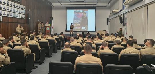 Wellerson Amarante, secretário de TI do TRE-MG, durante palestra. Junto dele há um telão com inf...