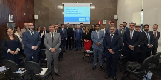 Desembargadores Carlos Henrique Perpétuo Braga e Sálvio Chaves posam com advogados em um pequeno...