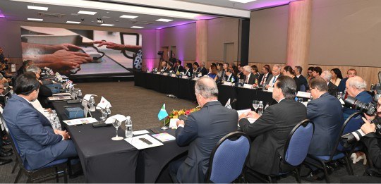 Presidentes dos TREs sentados ao redor de uma mesa em formato de U, durante reunião. Eles olham ...