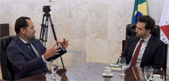 Desembargador Ramom Tácio e deputado Tadeu Leite, sentados ao redor de uma mesa.