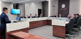 Foto mostra integrantes da Corte Eleitoral sentados ao redor de uma mesa em formato de U. No can...
