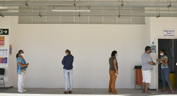 Foto de eleitores na fila de uma seção eleitoral.