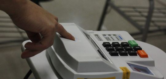 Foto do eleitor fazendo a leitura biométrica