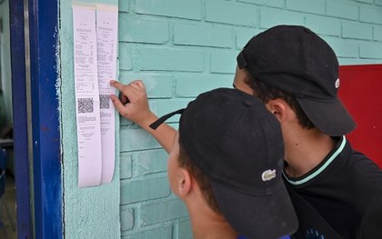 Homem com deficiência visual usa um fone de ouvido na cabine de votação