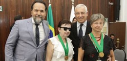 Foto entrega de medalha para duas servidoras, junto com dirigentes