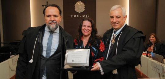 Foto do recebimento de placa de homenagem pelo des. Ramom Tácio de Oliveira