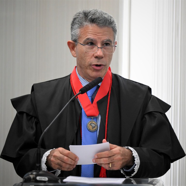 Procurador homenageado José Jairo Gomes, branco, cabelos grisalhos, está na tribuna discursando ...