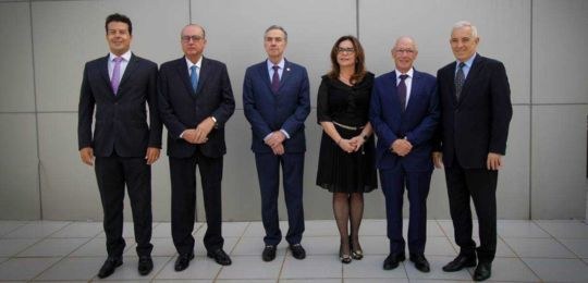 Foto de autoridades em pé, em reunião do TRF 6