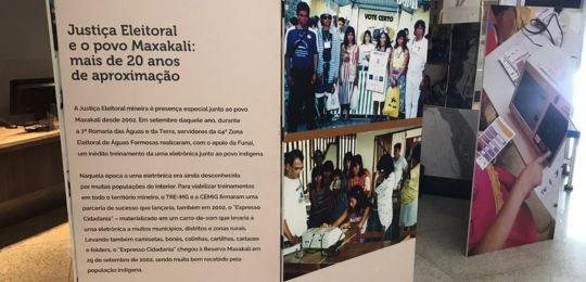 Biombo de exposição com fotos  de populações indígenas e a frase Justiça Eleitoral e o povo Maxa...