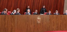 Ministros na Sala de Sessões do TSE tendo à frente o Brasão da República