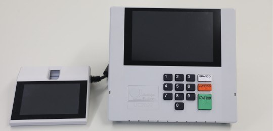 Foto da urna eletrônica modelo 2022, com terminal do mesário do lado esquerdo.
