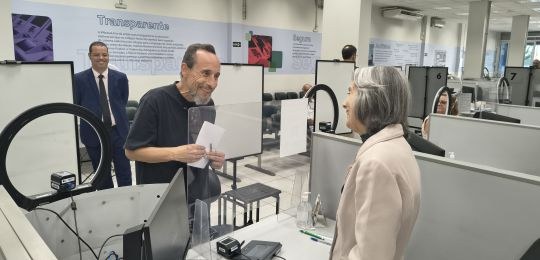 Ministra Cármen Lúcia, sorrindo, conversa com um eleitor